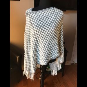 Grey and white poncho with fringe.